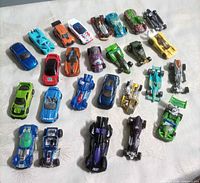 Group shot of approx. 25 Hot Wheels cars laid out on fabric surface