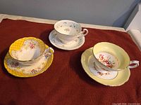 Three teacup and saucer sets displayed upright