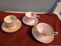 Three teacup and saucer sets displayed upright