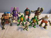 Front view of all eight TMNT figures lined up on table