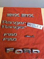 Full layout of all Ford emblems on red cloth