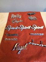 All emblems spread on red cloth, showing quantity and variety