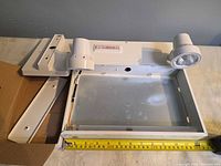 Top view of Lumacell unit showing open housing, two lamp heads, wiring, ruler indicating ~13 inch width, additional mounting bracket