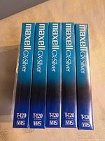 Front view of five sealed Maxell GX-Silver T-120 VHS tapes standing upright