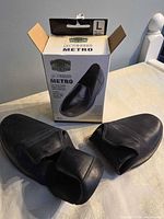 pair of black overshoes beside original box