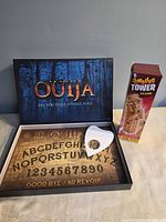 Open Ouija box showing printed board, planchette, and Tumbling Tower box