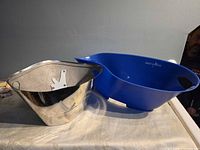 Silver and blue Grey Goose ice buckets side by side showing profiles