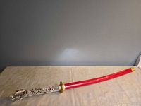 Full view of sword in red scabbard
