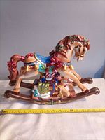 Left-side view showing full rocking horse with presents and measuring tape for length