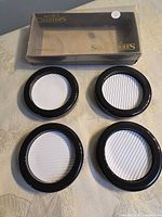 Four coasters beside original box