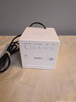 Front view showing Sony logo, display window, control buttons and attached AC cord