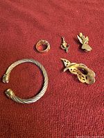 Five jewelry pieces laid out on red fabric