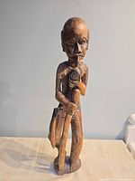 Front view of solid wood male figure holding staff