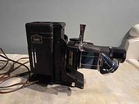 Side view of projector showing body plaque, power cord and reel arm