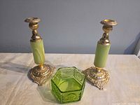 pair gilt candlesticks and hexagonal green glass dish on table