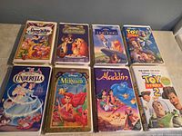 Front covers of eight Disney VHS tapes in clamshell cases