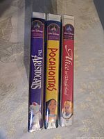 Spine view of three sealed Walt Disney Masterpiece Collection VHS tapes: The Aristocats, Pocahontas, Alice in Wonderland