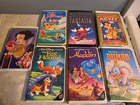 Front view of seven Disney VHS tapes with clamshell cases