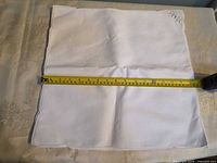 Napkin laid flat with tape measure showing width