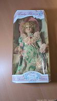 Front view of boxed Early Blossom porcelain doll