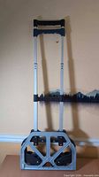 Hand truck folded with wheels visible