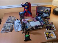 Overview of all items including LEGO set box, Superman statue, packaged figures, trays of accessories