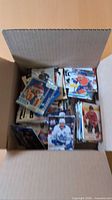 open cardboard box filled with hockey trading cards, assorted brands visible