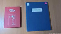 Blue binder and red Classic folder side by side
