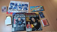 Overview of calendar, magazines, sealed card boxes, loose cards, card case and storage box