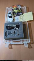 Entire set in case: white RC car, manual, decals, transmitter in foam, bag of parts