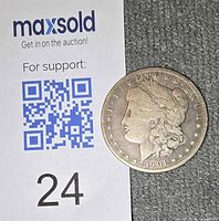 Obverse of 1901 Morgan dollar beside scale card