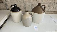 All three stoneware jugs grouped on table