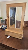 Front view of pine mirror with storage box on dining table