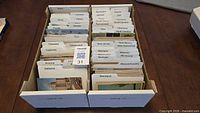 Overview of two collector boxes filled with state-sorted postcards