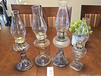 Group shot of the four antique glass oil lamps on table
