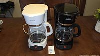 Both Sunbeam coffee makers side by side showing overall condition, colors and carafes