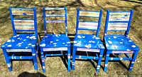 Front view of all four blue painted chairs outdoors