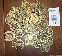 Scattered view of all 30 brass medallions on wood surface