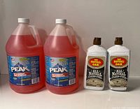 Front view of two Peak antifreeze jugs and two Royal Oak clean-fuel bottles