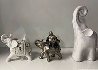 All three elephant figurines side by side for scale and comparison