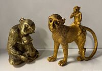 Both gold resin monkey figurines front view