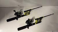 Two matching Profishiency spincast rod and reel combos laid out side by side
