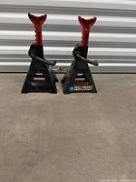 Front view of both black steel jack stands with red posts