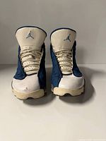 Front view of both sneakers showing tongue logos, lace area, toe condition