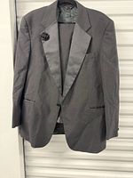 Front of charcoal tuxedo jacket with satin lapel and boutonnière