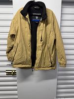 Front view of tan Weatherproof jacket on hanger