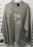 Full view of grey long-sleeve shirt on hanger showing design