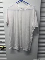 Front view of white men’s T-shirt on hanger showing overall condition and size label area