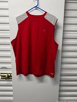 Full front view of red sleeveless shirt hanging
