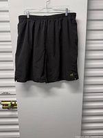 Front view of black Russell men’s athletic shorts hanging